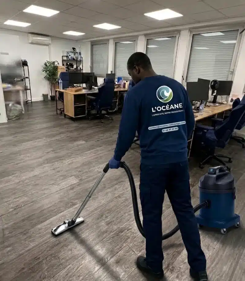 Agent L'OCÉANE effectuant une prestation de nettoyage de bureaux à Paris avec aspirateur professionnel