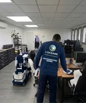 Agent L'OCÉANE en uniforme réalisant le nettoyage d'un bureau professionnel en Île-de-France